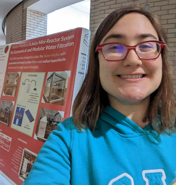 Alayna Mikush stands in front of a research poster